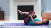 Woman laying on a mat performing a piriformis stretch.
