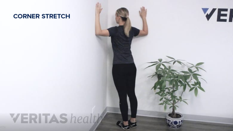 Therapist showing corner stretch exercise.