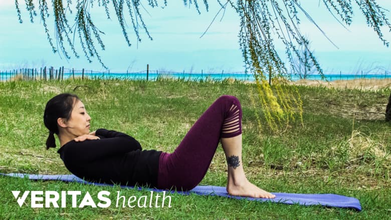 Woman performing abdominal curl ups outdoors