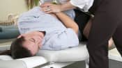 Chiropractor manipulating a patient&#039;s lower back