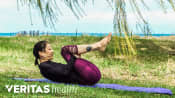 Woman lying on the ground performing a back flexion stretch