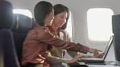 Two women talking while sitting in an airplane
