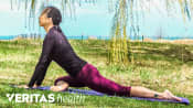 Woman outdoors doing a buttocks stretch.
