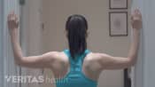 Woman performing the corner stretch for neck pain