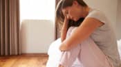 Woman sitting on the bed with head pain