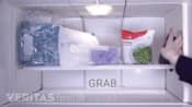 Woman grabbing an ice pack out of the freezer.
