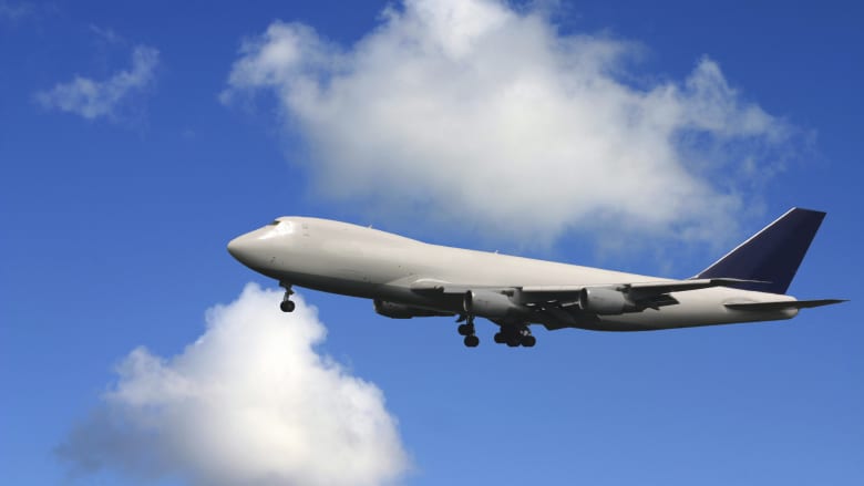 Airplane flying in the blue sky and clouds.
