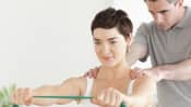 Chiropractor working with a patient using resistance bands.