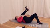 Woman lying supine doing Single Knee to Chest SI Joint Stretch