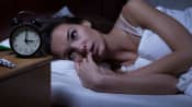Woman awake with insomnia in her bed.