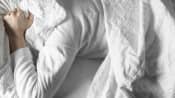 Woman struggling to sleep with head under the pillow