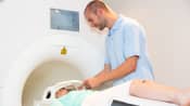 MRI tech helping patient through MRI