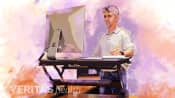 Man using a standing desk converter in his office