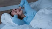 Woman lying awake in her bed.