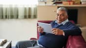 Man recovering at home while on his tablet.