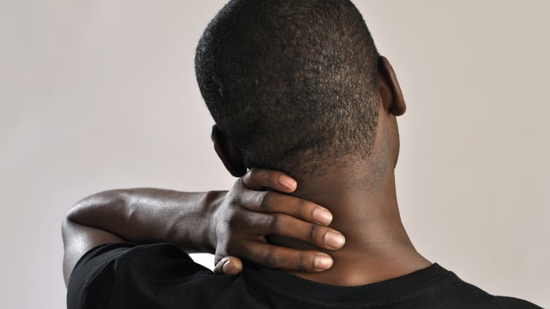 Man holding their neck in pain