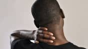 Man holding their neck in pain