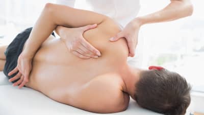 Physical therapist manipulating patient&#039;s shoulder