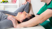 Therapist assisting patient with shoulder stretch.