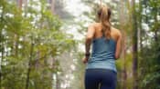 Woman running through the woods.