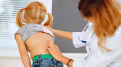 Doctor examining young patient&#039;s spine