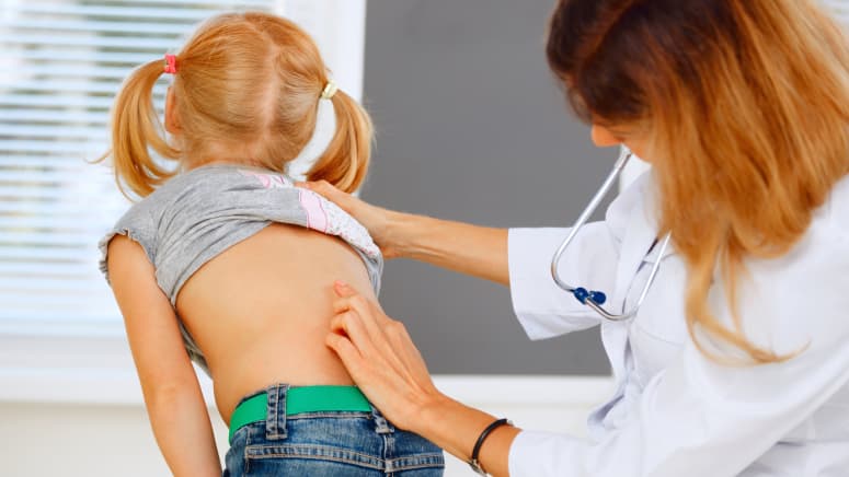 Doctor examining young patient&#039;s spine