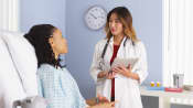 Patient in hospital bed talking with doctor