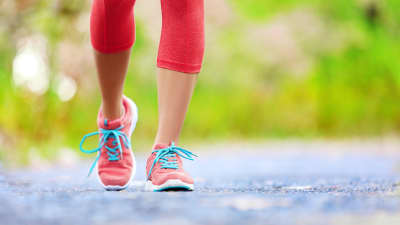 Women&#039;s feet walking with sneakers.
