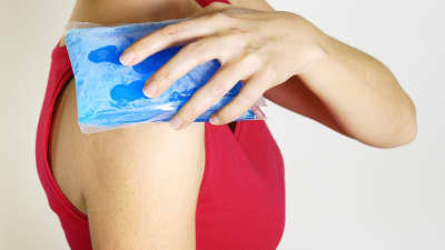 Gel pack icing a woman&#039;s shoulder