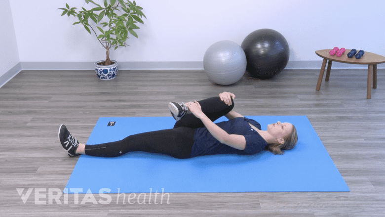 Picture of a physical therapist performing a supine piriformis stretch.